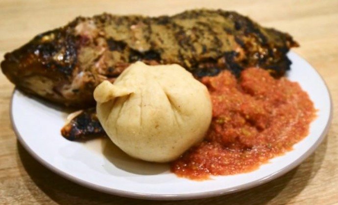 A plate of African food with jollof rice, plantain and grilled meat